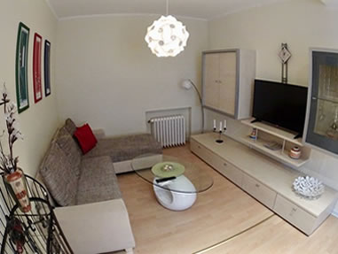Das gemütliche Wohnzimmer einer Ferienwohnung im Ferienzentrum Albert Schweitzer in Vöhl mit Couch und TV.